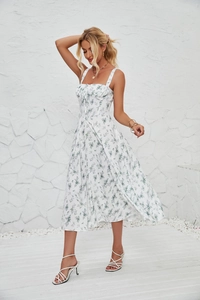 Detail of white floral sleeveless dress with green leaf print on a sunny terrace