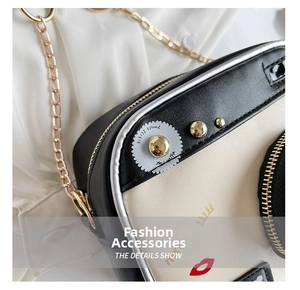 Macro view of camera-shaped crossbody bag with gold rivets and metallic chain strap