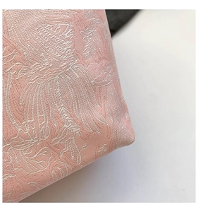 Macro shot of traditional pink jacquard fabric with high-density embroidery detail