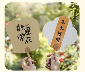 Close-up of Chinese calligraphy fans with Luck and Good Fortune prints in warm outdoor light