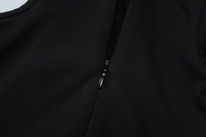 Detail of invisible zipper closure and fine texture on a black high-neck midi dress