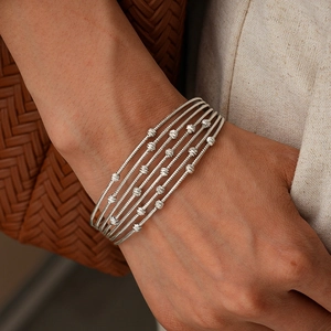 Macro detail of multi-layered silver beaded bracelet with textured metallic pearls