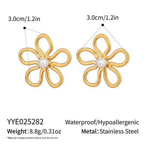 Détail de boucles d'oreilles fleurs plaquées or 18 carats avec perles en acier inoxydable
