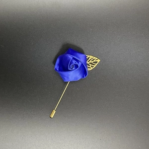 Detail showing royal blue satin rose brooch with gold hollow leaf and long needle pin