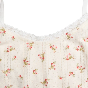 Close-up of white lace trim and red floral cotton fabric on a V-neck strapless dress