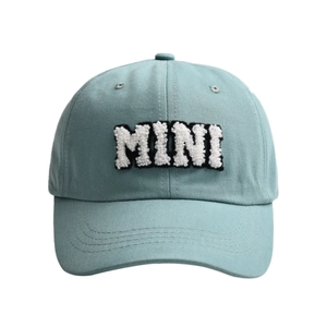 Close-up of light blue cotton baseball cap featuring white bouclé MINI embroidery