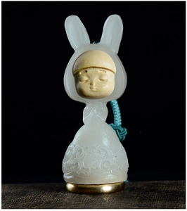 Close-up of a carved wooden rabbit diffuser pendant with jade-like resin and gold base