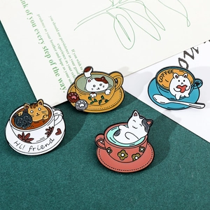 Detail view of colorful cat and rabbit coffee cup enamel pins on a minimal card