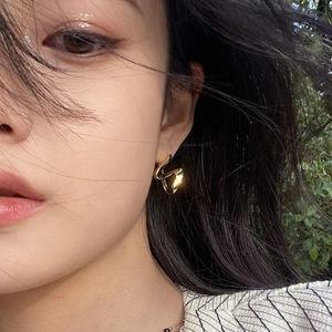 Minimalist 18K gold-plated S-shape wave hoop earrings worn by model in natural light