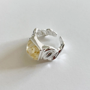 Close-up of irregular textured S925 silver ring with embedded yellow natural stone