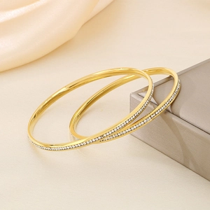 Luxurious gold titanium steel round bangle with sparkling crystals in high-end finish