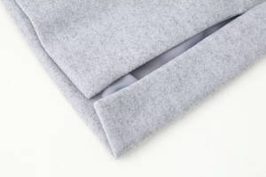 Vue macro détaillée de la texture du tissu en laine gris clair sur le manteau d'hiver
