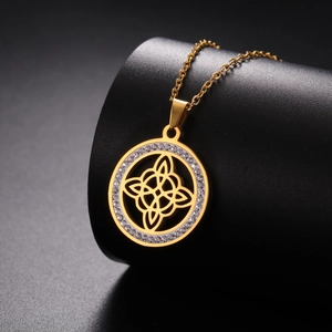 Vue détaillée du pendentif nœud de sorcière doré avec cristaux sur support noir