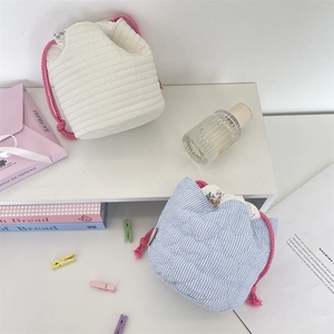 Detail of quilted drawstring storage bags featuring floral lining and cotton ropes