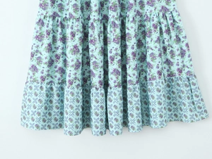 Detail of light blue floral tiered skirt with purple flower print and ruffled hem