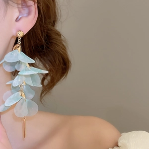Détail de longues boucles d'oreilles fleurs en tulle bleu avec accents en métal doré