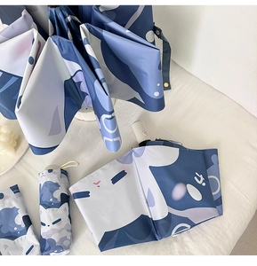Close-up of cute cat print on blue and white folding umbrella with matching storage pouch