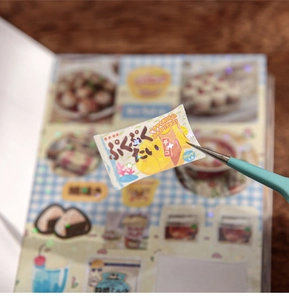 Detail of vintage food packaging sticker with laser flash effect held by blue tweezers