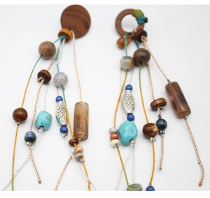 Detail of bohemian drop earrings featuring colorful wooden beads and ethnic tassel design