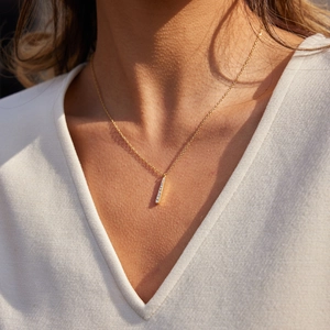Collier minimaliste en titane doré avec pendentif barre verticale serti de zircons fins