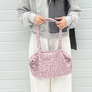 Dettaglio della borsa tote rosa leopardata con grande capacità e tessuto scamosciato