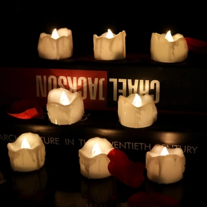 Eight flameless LED candles with melted edge design and warm light on dark books