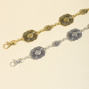 Detail of vintage metal chain belt showing sunburst engraved discs and lobster clasp