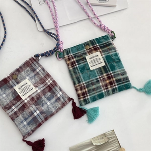 Detail shot of vintage plaid crossbody bags with fringe tassels and woven straps