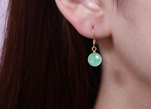Close-up of elegant green aventurine bead earrings worn by a model with golden hooks