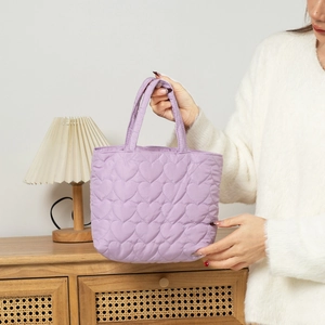 Close-up of heart quilted purple tote bag featuring soft nylon texture and carry handles