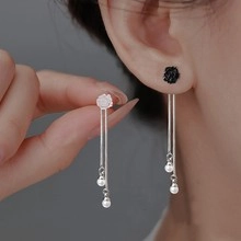 Dettaglio orecchini pendenti in argento con design a fiore e perle bianche eleganti
