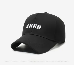 Close-up of white ANED letter embroidery on black cotton baseball cap with curved brim