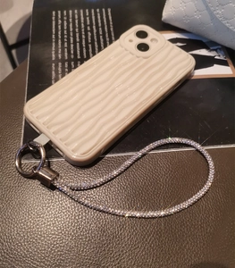 Close-up of cream white wave pattern phone case with luxury rhinestone wrist strap