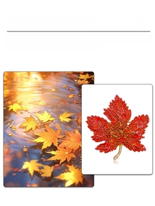 Macro shot of maple leaf brooch with orange rhinestones and gold-tone metal plating