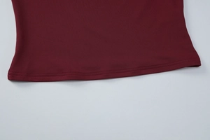 Détail de couture sur l'ourlet du haut ajusté en dentelle couleur bordeaux