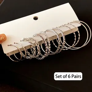 Detail of 6 pairs silver C-shape hoop earring set featuring smooth and twisted textures