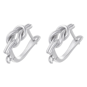 Macro shot of silver knot-shaped earrings with hooks on a clean white background