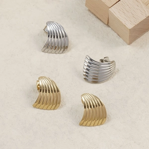 Macro detail of 18K gold and silver stainless steel fan-shaped earrings with shell texture