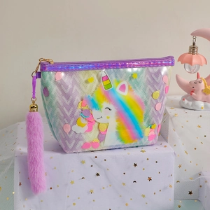 Detail view of rainbow unicorn cosmetic bag with purple plush keychain on star mesh background