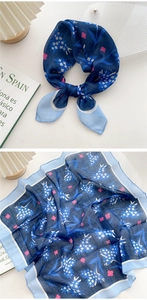 Detailed view of lightweight floral silk scarf with soft blue patterns and light blue borders