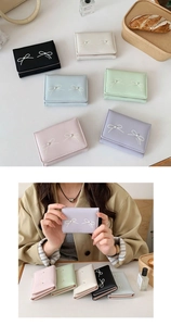 Close-up of bow embroidered short wallets with pearl detail in six pastel colors