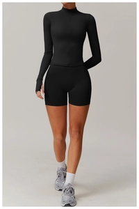 Detail of black zip-up sports top with thumbhole sleeves and high-waisted gym shorts