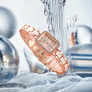 Detail of rose gold square watch with crystal bezel and ceramic links in splashing water