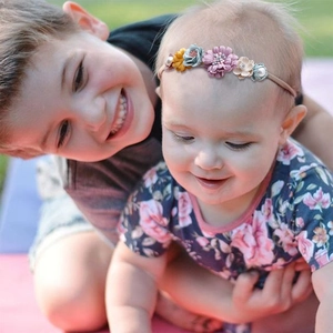 Detail of baby flower headband with elastic band, artificial flowers and pearl accents