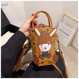 Detail view of brown bucket bag with cartoon bear prints and 3D rabbit decoration