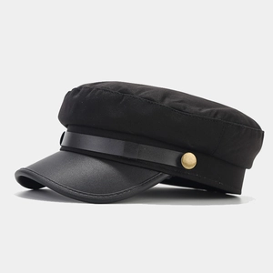 Detail of vintage navy cap showing black fabric body and textured leather brim