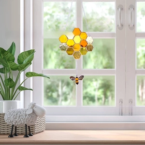 Detailed suncatcher view with amber acrylic honeycomb panes and a delicate bee pendant