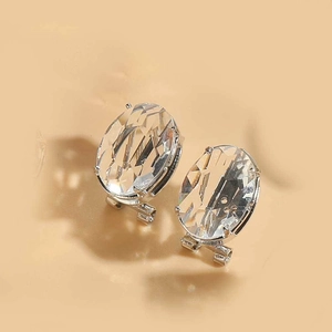 Dettaglio di orecchini ovali in acrilico sfaccettato con placcatura argento e base in oro 14K