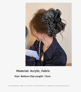 Macro view of 13cm large paisley fabric bow hair claw clip with black acrylic base