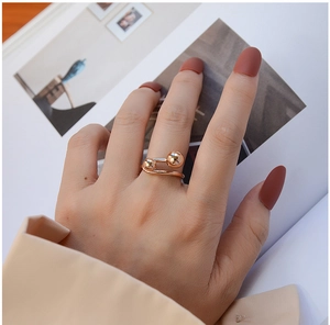 Close-up of minimalist rose gold double ball open ring on model with stylish magazine backdrop